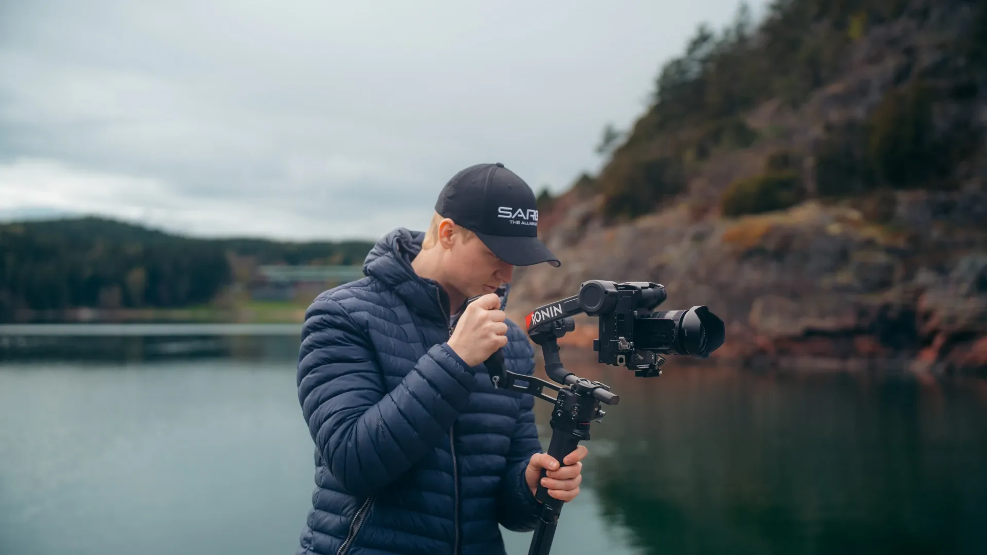 Videograf med kamera på gimbal ved et vann
