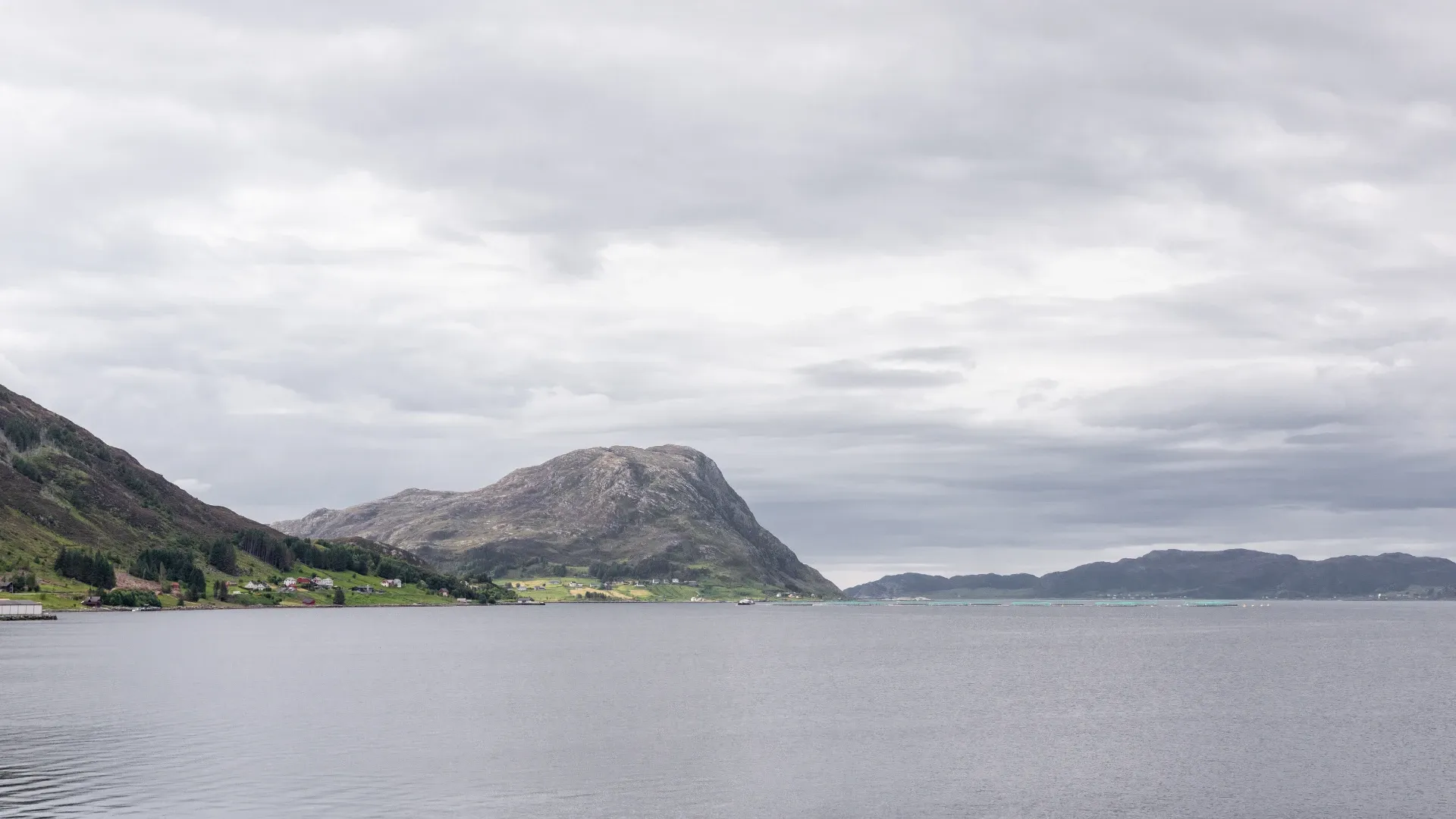 Fjordlandskap med fjell og grå skyer